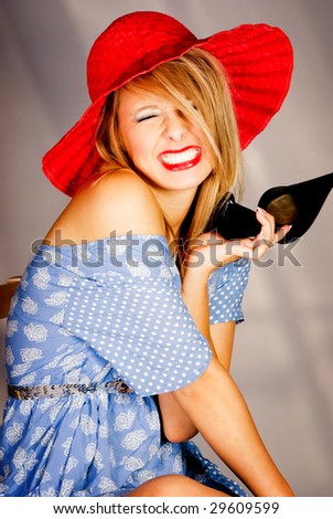 Teenage girl in red floppy hat playing with shoe