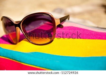 vacations concept with bag and glasses on the sand