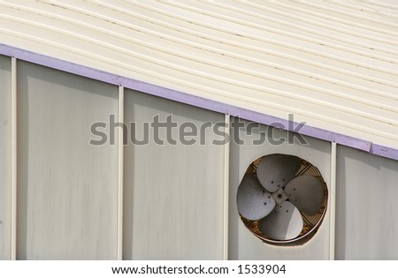 Ventilation fan outlet on the side of a restaurant building.