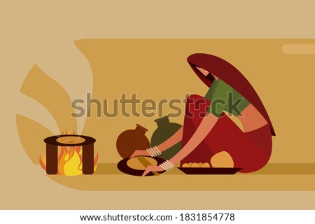 Indian woman making 'Roti' in traditional way on a fire stove
