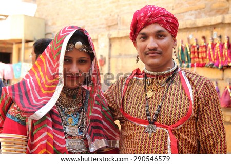 JAISALMER, INDIA - FEB 03: Unidentified Rajasthani couple dressed up in traditional  costume and pose in front of a shop during Desert Festival on February 03, 2015 in Jaisalmer, Rajasthan, India.