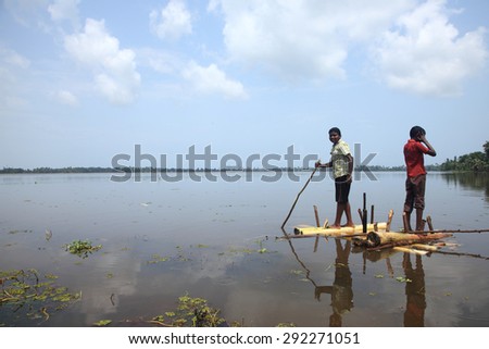 KUTTANAD, INDIA - MAY 26 : Unidentified boy rows a raft made out of banana stem in the backwaters on May 26, 2012 in Kuttanad,Kerala, India. Kuttanad is known as the lowest altitute region in India.