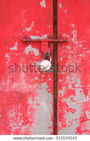 Closed old red color metal door with a lock