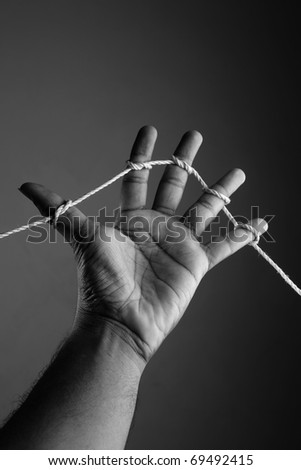 conceptual image of a hand with all fingers tied with a rope