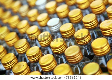 Rows of golden color bottle caps with shallow depth of field
