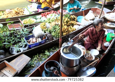 RATCHABURI, THAILAND - FEB 13: A local Thai woman makes Thai food at Damnoen Saduak floating market on February 13, 2011 in Ratchaburi, Thailand. Damnoen Saduak is famous for traditional Thai food.