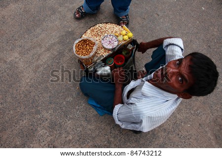 KOLKATA - OCTOBER 16: Street vendor of peanuts aka \'Channa Walla\' communicate with his customer on 16, 2010 in Kolkata, India. Toasted  chickpea is most common and a favorite street food in India.