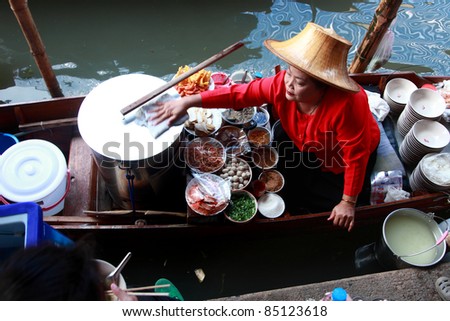 RATCHABURI, THAILAND - FEB 13: A woman makes Thai food at Damnoen Saduak floating market on February 13, 2011 in Ratchaburi, Thailand. Its popular for traditional style Thai food and old Thai culture.