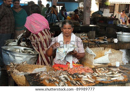 TRIVANDRUM - DEC 02: Unidentified woman sells fish in a crowded market on December 02, 2011 in Chalai,Trivandrum, India. Chalai is the biggest market in the capital city of Kerala state.