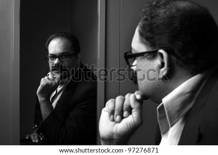Business man seeing his reflection in the mirror