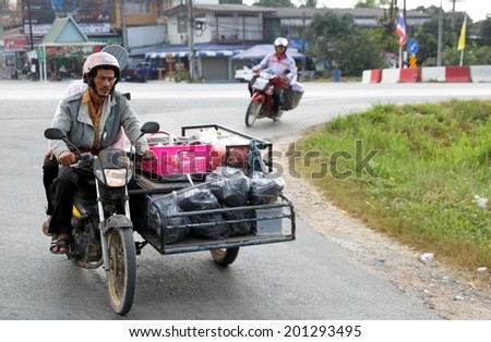 BANGKOK - JANUARY 10 : An unidentified rider transporting goods by road on January 10, 2013 in Bangkok, Thailand. Motorbikes with stroller used for transportation of foods