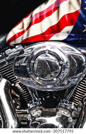 Close up motor and the fuel tank of a motorcycle with an American flag