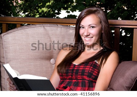 Beautiful Girl Reading a Book in the Patio