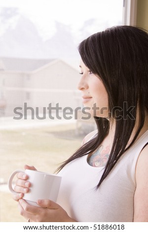 Woman by the Bedroom Window with a Cup of Coffee in the Morning