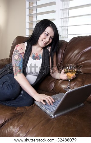 Woman Relaxing on the Couch with a Glass of Wine and Laptop