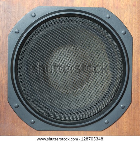Subwoofer Loud speaker system with round black grill and wooden finish closeup