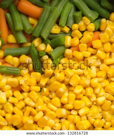 Steamed vegetables: sweet corn, green string beans and carrots closeup
