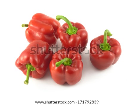 Five whole red ripe bell peppers isolated on white close up