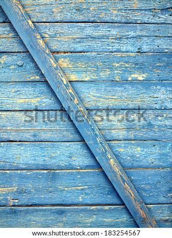 Fragment of  wall with horizontal boards with nailed diagonal slats, painted old blue paint as texture closeup