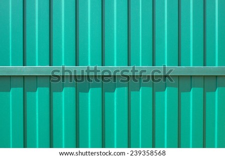 Green metal vertical fence as background closeup