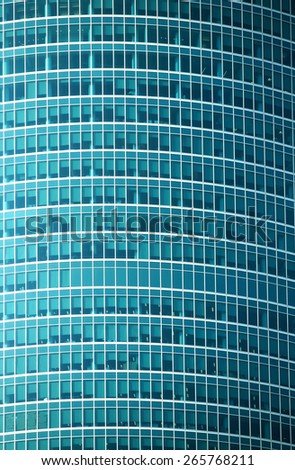 Glass wall of modern office building with many large panoramic windows in business cluster vertical front view close-up