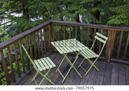 Small metal table and folding chairs on a deck