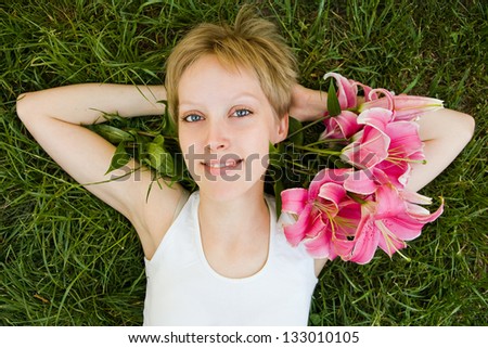 Beautiful girl laying in the grass with flowers in her hair