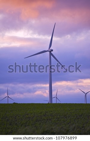 Future Power - Sunset. Wind Turbines Plantation Vertical Photography. Power Industry Theme. Technology Photo Collection.