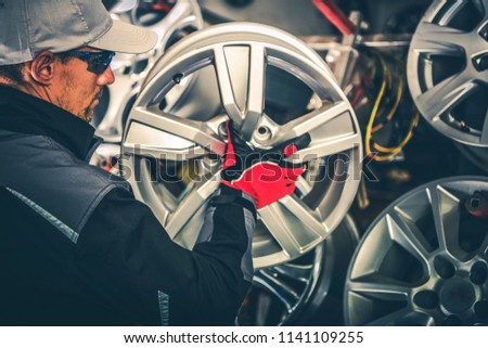 Buying New Alloy Wheels and Seasonal Tires Change Concept Photo. Caucasian Car Service Worker with Large Rim in Hands. Stock fotó © 