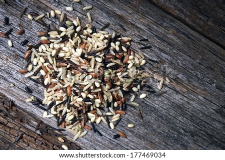 Mixed of Wild Organic Rices on Aged Wood Table Closeup.