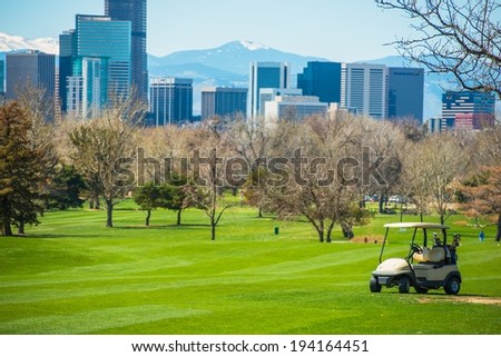 Colorado Golf Field with Denver Skyline and Golf Cart.