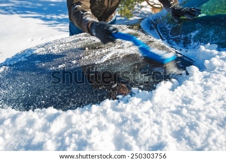 Snow Removal From Car. Men Cleaning Car From the Snow.