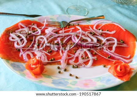 Beautiful  composition of an appetizer  dish, smoked salmon, onions, focus on the middle.