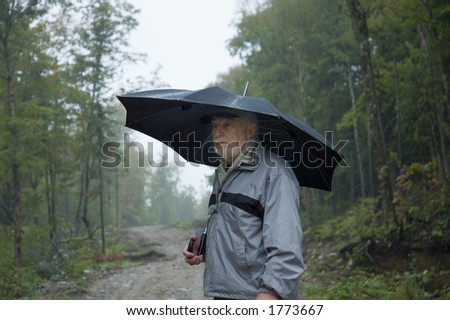 Elderly walking on a path by a rainy day