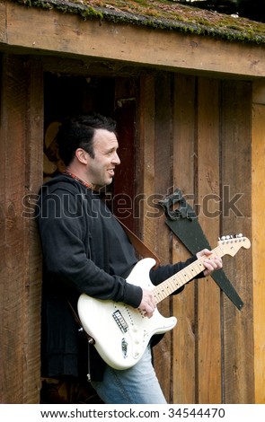 sexy guitarist with a cute look with rustic background, Quebec, Canada