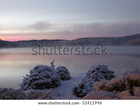 Sunset over a lake after snow storm at twilight time in Quebec Province, Canada
