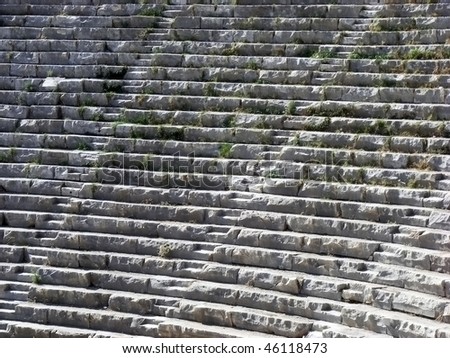 The ancient amphitheater with neat rows of stone seats and passages for the audience