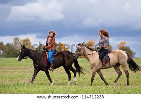 Two girls ride beautiful Akhal-Teke horses