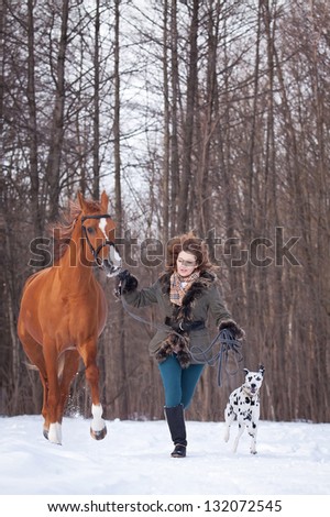 Beautiful young woman with a dalmatian dog and a horse of Don breed