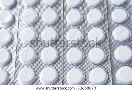 White pills packed in tin blisters