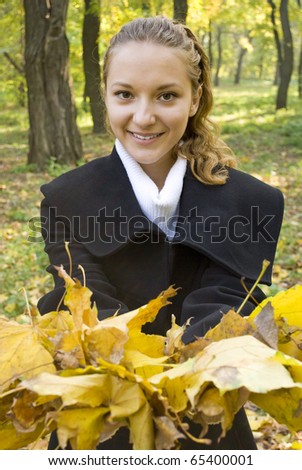 Young cute girl with a bunch of gold leaves in the hands