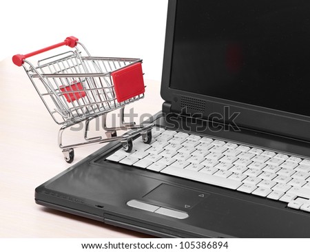 Online shopping. trolley on laptop isolated on white