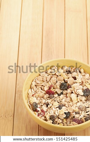 Delicious and healthy cereal in bowl with milk and bananas on table in room