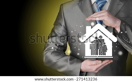 businessman protecting family in home with hands
