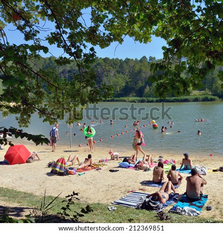 MAZAN, FRANCE - JUL 19, 2014: People have a rest on the shore of lake in southern France, Provence. A  lot of small lakes is a popular recreation areas for local people to avoid summer heat