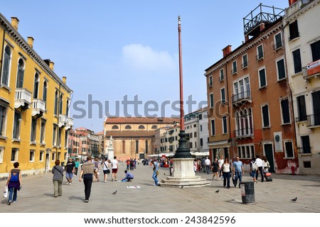 VENICE, ITALY - SEPT 21, 2014: Tourist walking on typical Venetian square Campo S. Stefan.Tourists from all the world enjoy the historical city of Venezia in Italy, famous UNESCO World Heritage Site