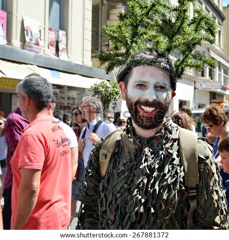 AVIGNON, FRANCE - JUL 12, 2014: Unidentified masked actor performs in the street, to advertise theater show, during the annual Avignon Theater Festival in Avignon
