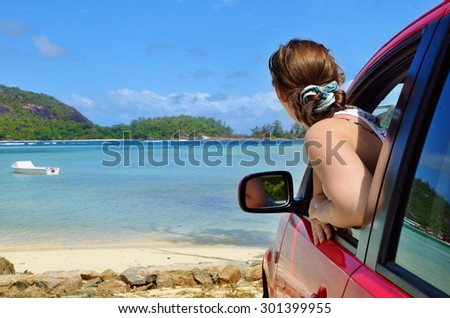 A place of a destination. Young driver woman looking on the sea from opened car\'s window