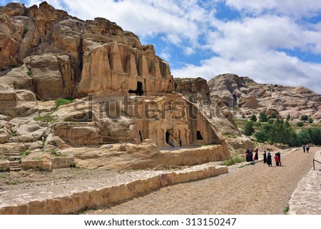 PETRA, JORDAN - APR 1, 2015: Tourists walking around Bab Al-Siq tomb in Petra. Petra\'s temples, tombs, theaters and other buildings are scattered over 400 square miles.