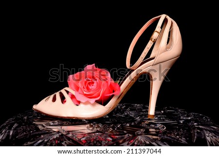 Woman's's Shoe and rose isolate over black on crystal